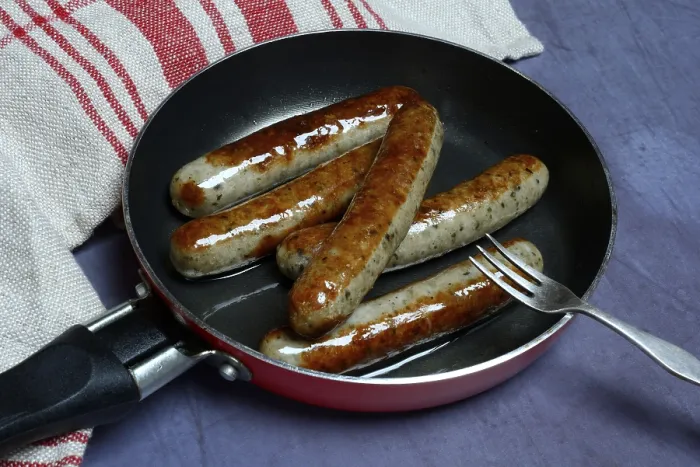 Gerahmter Druck : Nürnberger Rostbratwurstchen in Pfanne. Gerahmter Druck : Nürnberger Rostbratwurstchen in Pfanne.