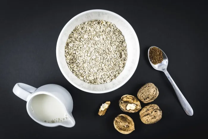 Gerahmter Druck : Haferflocken in einem Becher und geflügelte Walnüsse. Gerahmter Druck : Haferflocken in einem Becher und geflügelte Walnüsse.