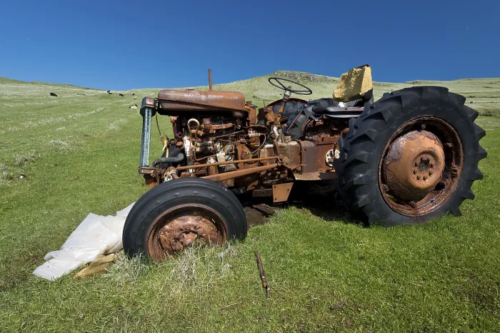 Gerahmter Druck : Ein alter rostiger Traktor steht in einem Wiesenfeld. Gerahmter Druck : Ein alter rostiger Traktor steht in einem Wiesenfeld.