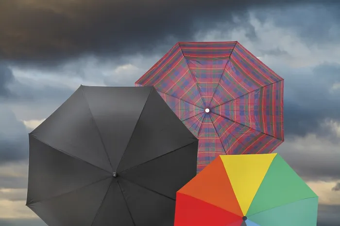 Gerahmter Druck : Offene Regenschirme mit stürmischem Grau-Himmel-Hintergrund. Gerahmter Druck : Offene Regenschirme mit stürmischem Grau-Himmel-Hintergrund.