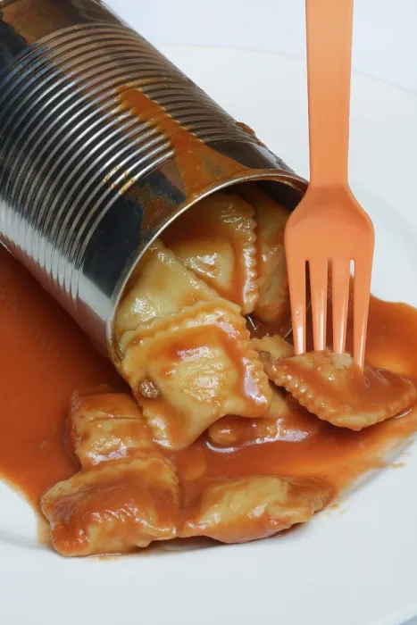 Gerahmter Druck : Geöffneter Blechbecher mit Ravioli und Gabel auf Teller. Gerahmter Druck : Geöffneter Blechbecher mit Ravioli und Gabel auf Teller.