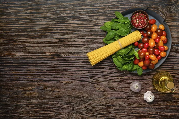 Gerahmter Druck : Überblicksansicht einer Handvoll roher Spaghetti mit Spinat. Gerahmter Druck : Überblicksansicht einer Handvoll roher Spaghetti mit Spinat.