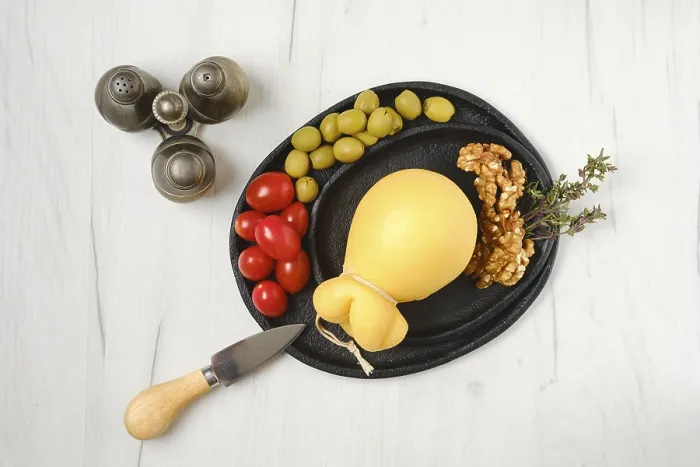 Gerahmter Druck : Überblicksansicht eines abgezogenen Scamorza-Käses auf einem Teller. Gerahmter Druck : Überblicksansicht eines abgezogenen Scamorza-Käses auf einem Teller.