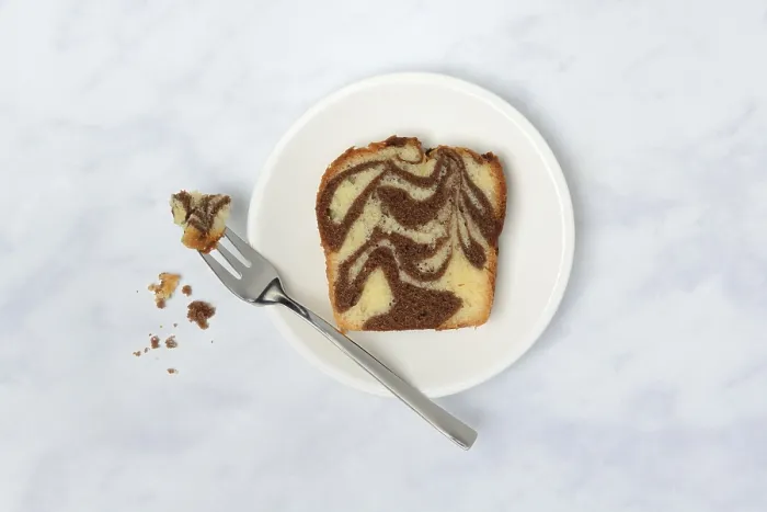 Gerahmter Druck : Ein Stück Marmorkuchen und ein Löffel auf einem Teller.