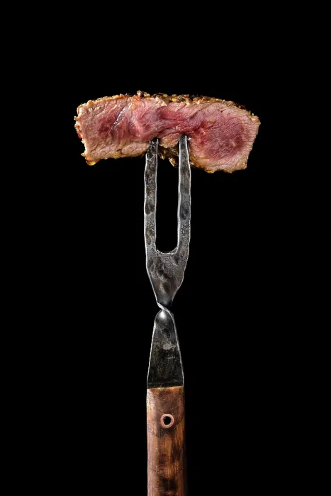 Gerahmter Druck : Stück Medium-Rare-Steak auf der Gabel. Gerahmter Druck : Stück Medium-Rare-Steak auf der Gabel.