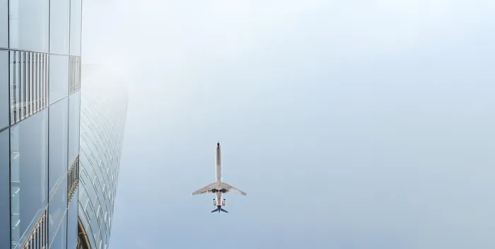 Gerahmter Druck : Ein Flugzeug fliegt über einen Wolkenkratzer. Gerahmter Druck : Ein Flugzeug fliegt über einen Wolkenkratzer.