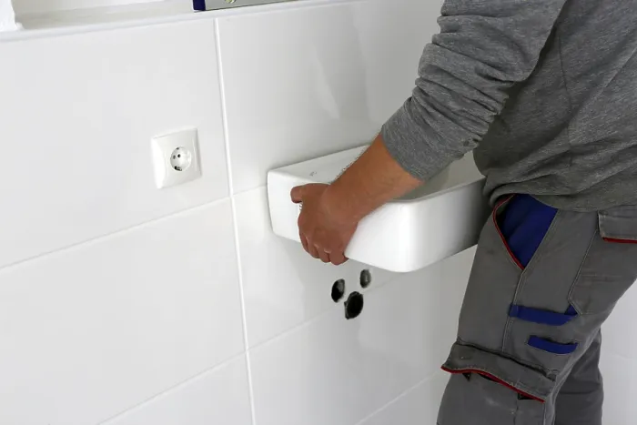 Gerahmter Druck : Der Installateur legt einen neuen Waschbecken ein. Gerahmter Druck : Der Installateur legt einen neuen Waschbecken ein.