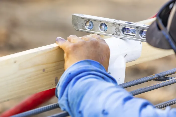 Gerahmter Druck : Der Schreiner verwendet ein Nivelliergerät, während er eine PVC-Rohrleitung auf einem Baustellen installiert. Gerahmter Druck : Der Schreiner verwendet ein Nivelliergerät, während er eine PVC-Rohrleitung auf einem Baustellen installiert.