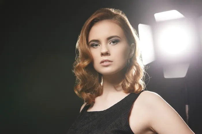 Gerahmter Druck : Bildnis einer schönen Model, die sich in einem Studio auf dem Hintergrund eines Scheinwerfers positioniert. Gerahmter Druck : Bildnis einer schönen Model, die sich in einem Studio auf dem Hintergrund eines Scheinwerfers positioniert.