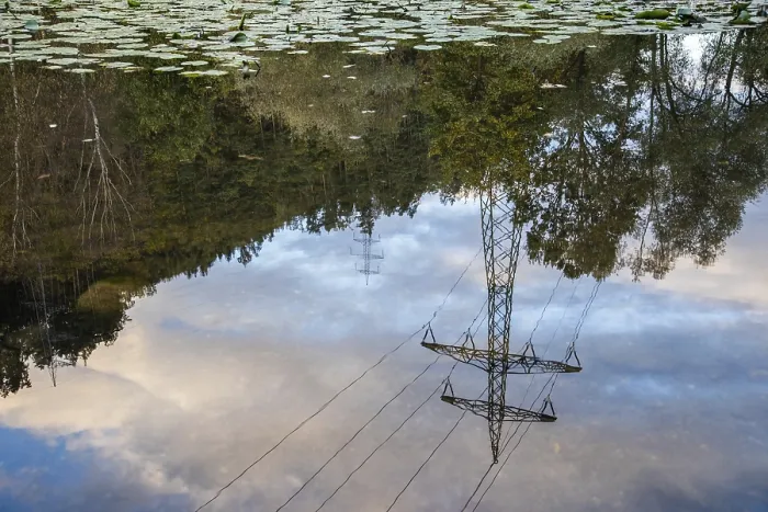 Gerahmter Druck : Leitermast einer Stromleitung im Spiegel eines Sees. Gerahmter Druck : Leitermast einer Stromleitung im Spiegel eines Sees.