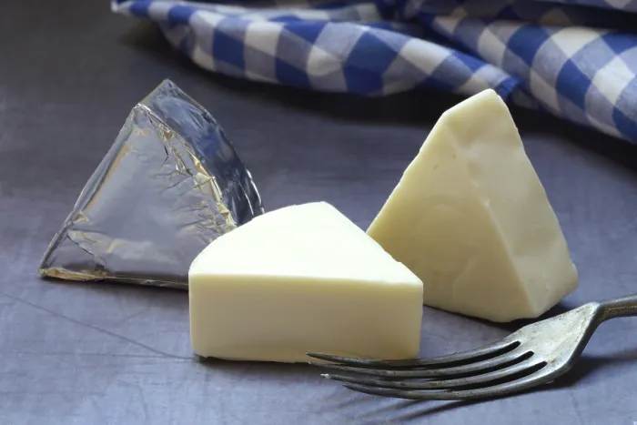 Gerahmter Druck : Verarbeiteter Käse, Käsescheiben mit Gabel. Gerahmter Druck : Verarbeiteter Käse, Käsescheiben mit Gabel.