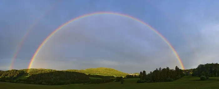 Gerahmter Druck : Regenbogen in einem hügeligen Landschaft mit Wald. Gerahmter Druck : Regenbogen in einem hügeligen Landschaft mit Wald.