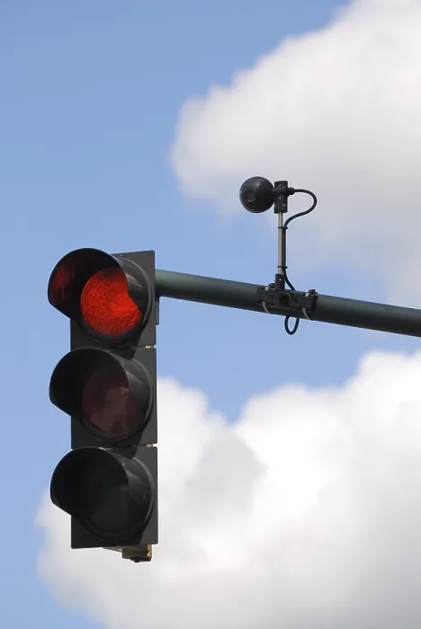 Gerahmter Druck : Rotes Lichtsignal mit Sensor gegen bewölkten Himmel.
