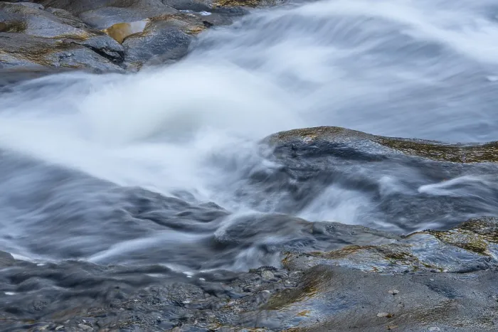 Gerahmter Druck : Reflexionen an einem Felsen am tosenden Bach. Gerahmter Druck : Reflexionen an einem Felsen am tosenden Bach.
