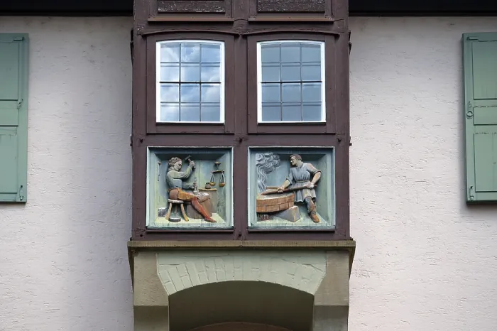 Gerahmter Druck : Reliefs mit Handwerksfiguren an einem Bogenfenster. Gerahmter Druck : Reliefs mit Handwerksfiguren an einem Bogenfenster.