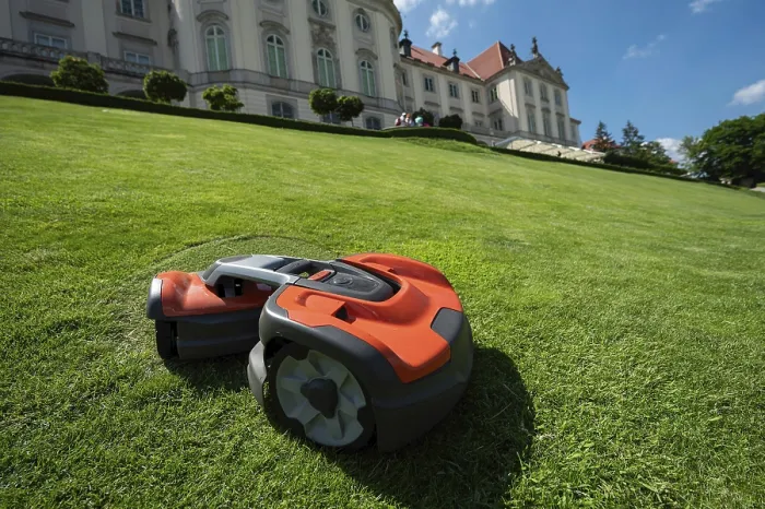 Gerahmter Druck : Ein Roboterrasenmäher mäht den Rasen auf einer Steigung. Gerahmter Druck : Ein Roboterrasenmäher mäht den Rasen auf einer Steigung.
