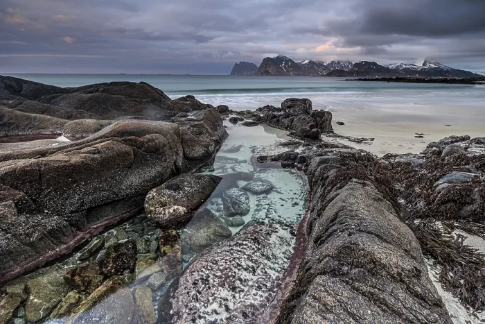 Gerahmter Druck : Felsen und Strand vor Bergen Gerahmter Druck : Felsen und Strand vor Bergen