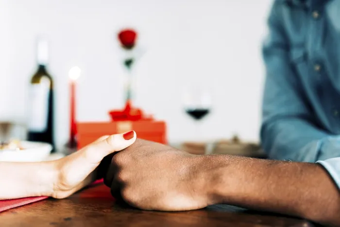 Gerahmter Druck : Ein romantischer Abendessen-Ambiente zeigt ein Paar, das sich die Hände über einem Tisch hält. Gerahmter Druck : Ein romantischer Abendessen-Ambiente zeigt ein Paar, das sich die Hände über einem Tisch hält.