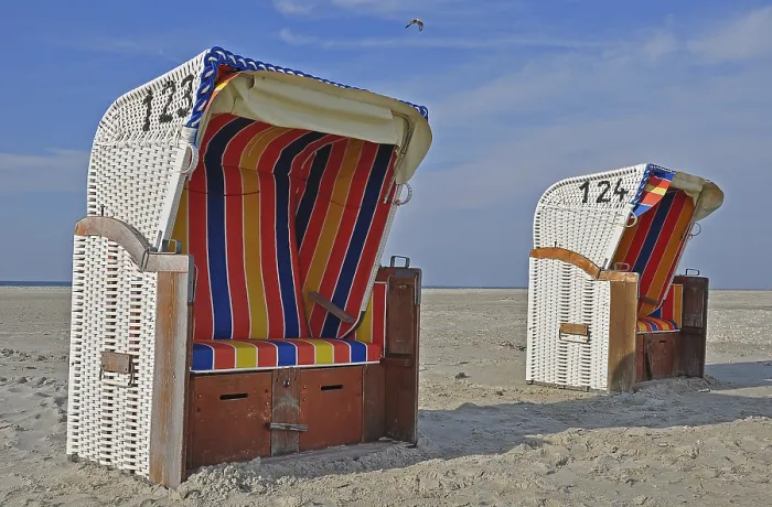 Gerahmter Druck : Zwei gedeckte Rattan-Sitzstühle am Strand. Gerahmter Druck : Zwei gedeckte Rattan-Sitzstühle am Strand.