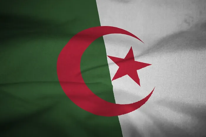 Gerahmter Druck : Gefaltetes Flaggen von Algerien weht in Wind.