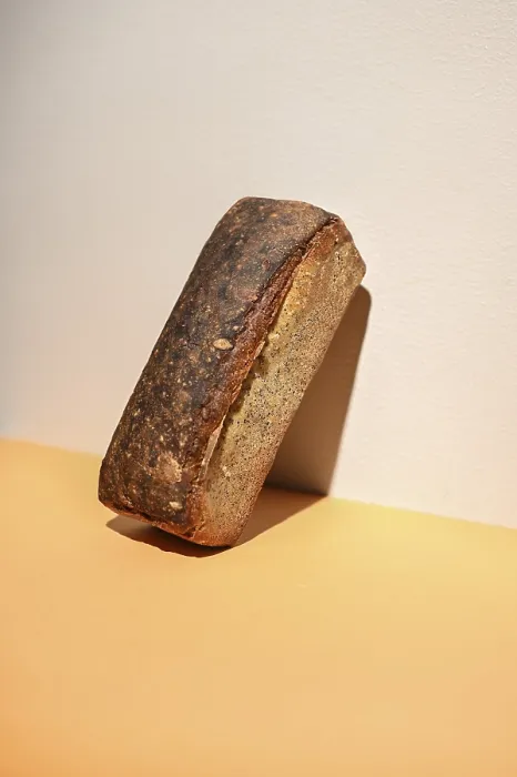 Gerahmter Druck : Ein rustikaler Laib Brot liegt an einer Wand. Gerahmter Druck : Ein rustikaler Laib Brot liegt an einer Wand.