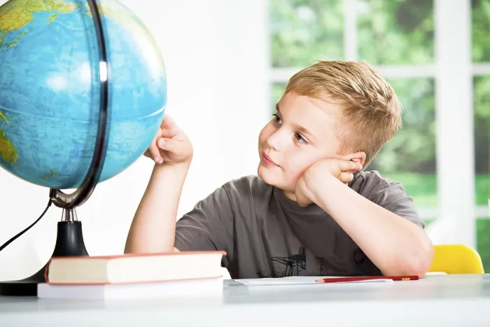 Gerahmter Druck : Ein Schuljunge mit einer Kugel der Erde. Gerahmter Druck : Ein Schuljunge mit einer Kugel der Erde.