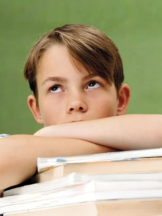 Gerahmter Druck : Schuljunge vor einem Schulblackboard mit einem Stapel Bücher.