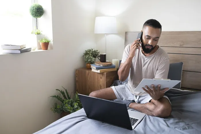 Gerahmter Druck : Vollansicht Mann arbeitet im Bett. Gerahmter Druck : Vollansicht Mann arbeitet im Bett.