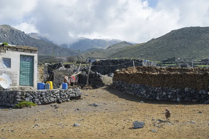 Gerahmter Druck : Ein einfaches Steinhaus mit Bergen im Hintergrund. Gerahmter Druck : Ein einfaches Steinhaus mit Bergen im Hintergrund.