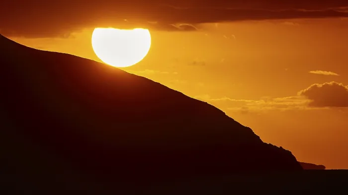 Gerahmter Druck : Untergehender Sonne hinter einem Bergabhang. Gerahmter Druck : Untergehender Sonne hinter einem Bergabhang.