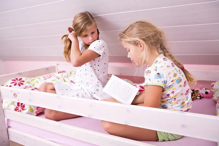 Gerahmter Druck : Schwestern lesen ein Buch im Bett. Gerahmter Druck : Schwestern lesen ein Buch im Bett.