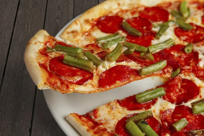 Gerahmter Druck : Stück schwebender Pizza mit Peperoni auf Schulterblatt. Gerahmter Druck : Stück schwebender Pizza mit Peperoni auf Schulterblatt.
