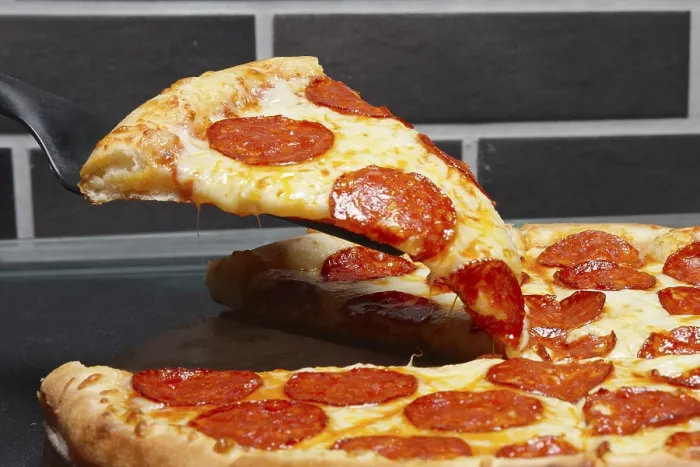 Gerahmter Druck : Stück Pizza mit Peperoni auf Schulterblatt. Gerahmter Druck : Stück Pizza mit Peperoni auf Schulterblatt.