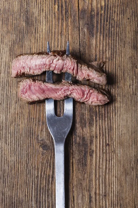 Gerahmter Druck : Ein Steak auf ein Fleischgabelscherbchen schneiden. Gerahmter Druck : Ein Steak auf ein Fleischgabelscherbchen schneiden.