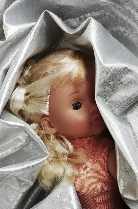 Gerahmter Druck : Kleine Puppe in silberfarbenem Stoff eingewickelt. Gerahmter Druck : Kleine Puppe in silberfarbenem Stoff eingewickelt.
