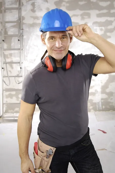 Gerahmter Druck : Lächelnder Arbeiter mit Helm.