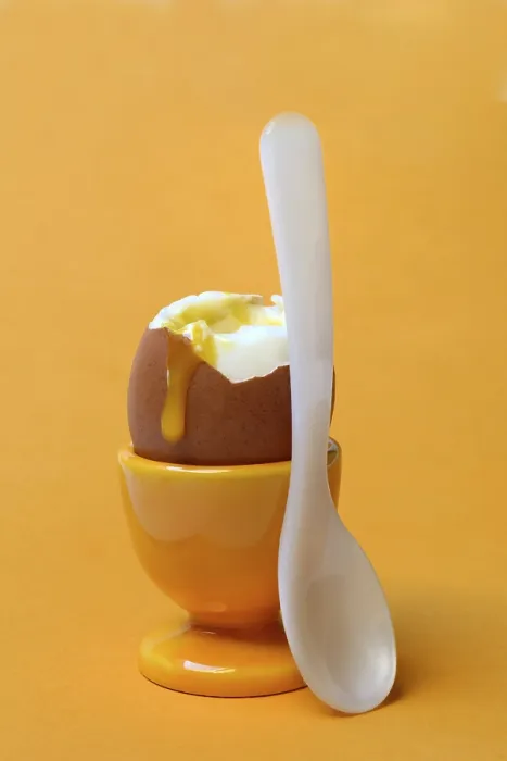 Gerahmter Druck : Weichgekochtes Frühstücksei in Eierbecher mit Löffel. Gerahmter Druck : Weichgekochtes Frühstücksei in Eierbecher mit Löffel.
