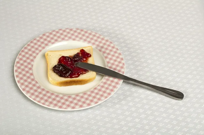 Gerahmter Druck : Brot mit Messer mit Marmelade bestreichen. Gerahmter Druck : Brot mit Messer mit Marmelade bestreichen.