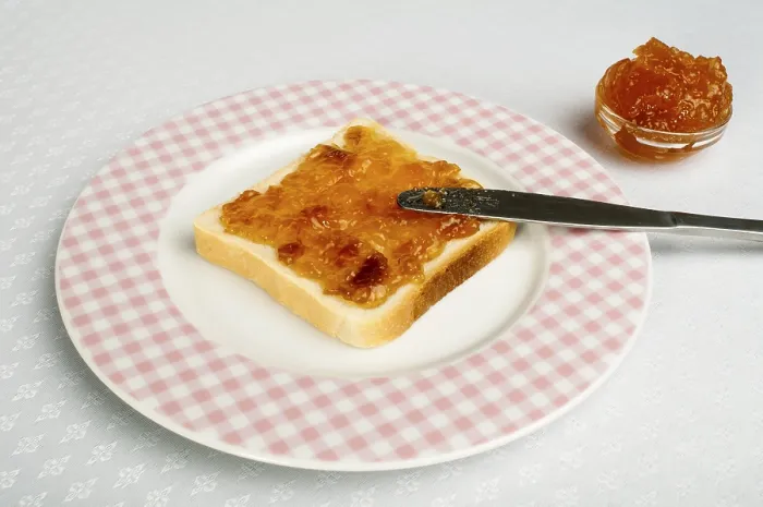 Gerahmter Druck : Brot mit Messer mit Marmelade bestreichen. Gerahmter Druck : Brot mit Messer mit Marmelade bestreichen.