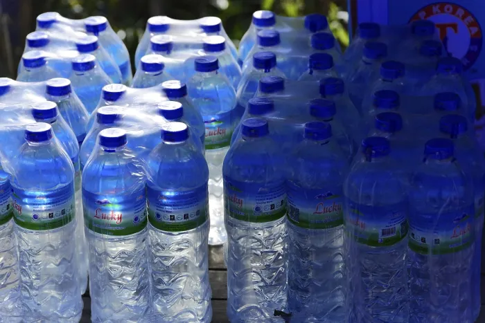 Gerahmter Druck : Ein Stapel blauer Wasserflaschen in einem Stand.
