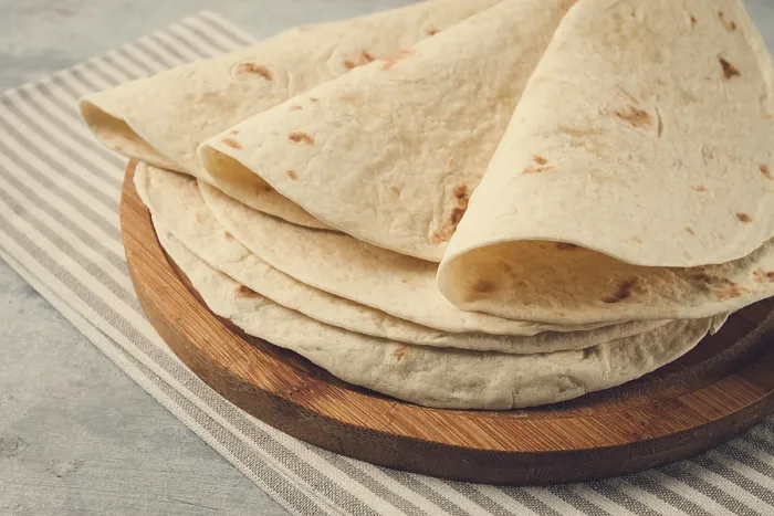 Gerahmter Druck : Ein Stapel mexikanischer Tortillas, auf einem grauen Tisch.