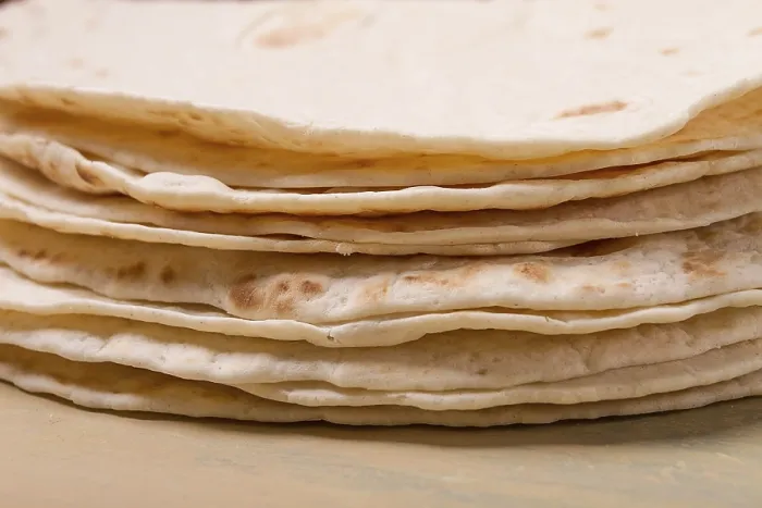 Gerahmter Druck : Ein Stapel mexikanischer Tortillas, auf einem grauen Tisch.