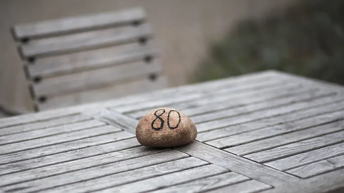 Gerahmter Druck : Stein mit Tischnummer auf einem Gartenstuhl. Gerahmter Druck : Stein mit Tischnummer auf einem Gartenstuhl.