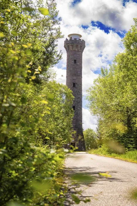 Gerahmter Druck : Ein steinerner Turm steht mitten in einem Wald. Gerahmter Druck : Ein steinerner Turm steht mitten in einem Wald.