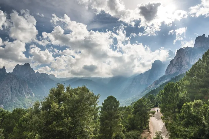 Gerahmter Druck : Straße durch ein Tal mit Klippen in den Wolken. Gerahmter Druck : Straße durch ein Tal mit Klippen in den Wolken.