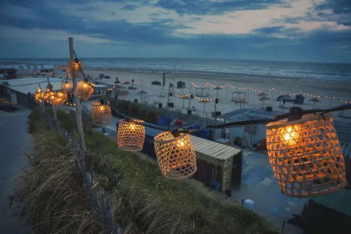 Gerahmter Druck : Faden von Lichtern am Strand bei blauer Stunde Gerahmter Druck : Faden von Lichtern am Strand bei blauer Stunde