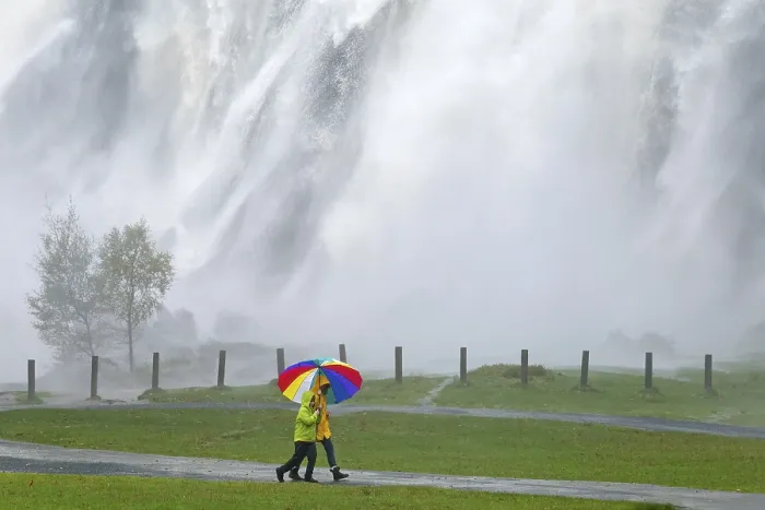 Gerahmter Druck : Wagen mit bunten Schirmen vor Wasserfall. Gerahmter Druck : Wagen mit bunten Schirmen vor Wasserfall.
