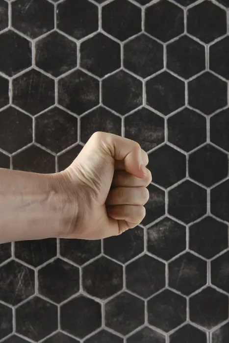 Gerahmter Druck : Ein starker Faustschlag ist vor einem texturierten hexagonalen Muster positioniert. Gerahmter Druck : Ein starker Faustschlag ist vor einem texturierten hexagonalen Muster positioniert.