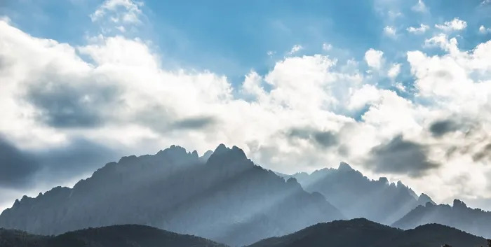 Gerahmter Druck : Sonne durch Wolken gegen Berge. Gerahmter Druck : Sonne durch Wolken gegen Berge.