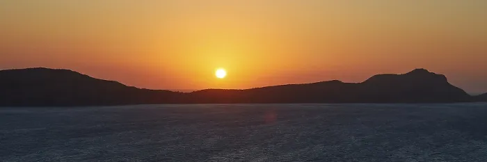 Gerahmter Druck : Die Sonne geht hinter dem Silhouette eines Berges unter. Gerahmter Druck : Die Sonne geht hinter dem Silhouette eines Berges unter.